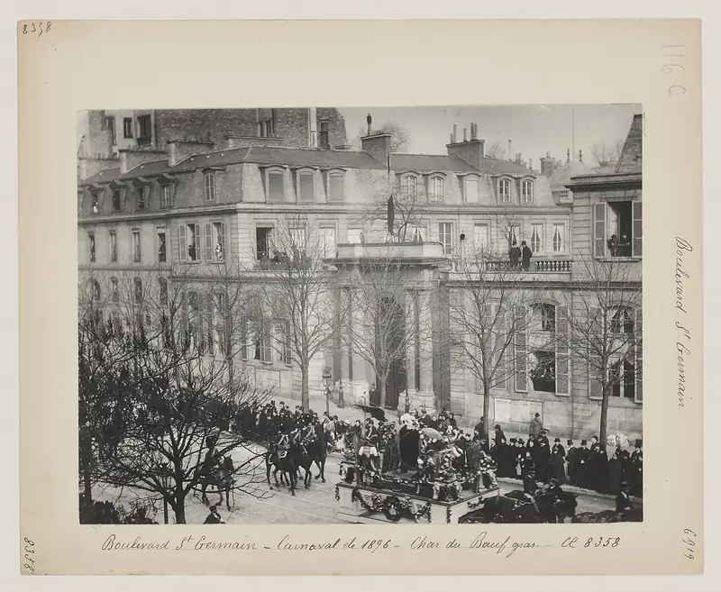 Photographie de 1896 : un char portant un bœuf décoré avance sur un boulevard parisien au milieu de la foule