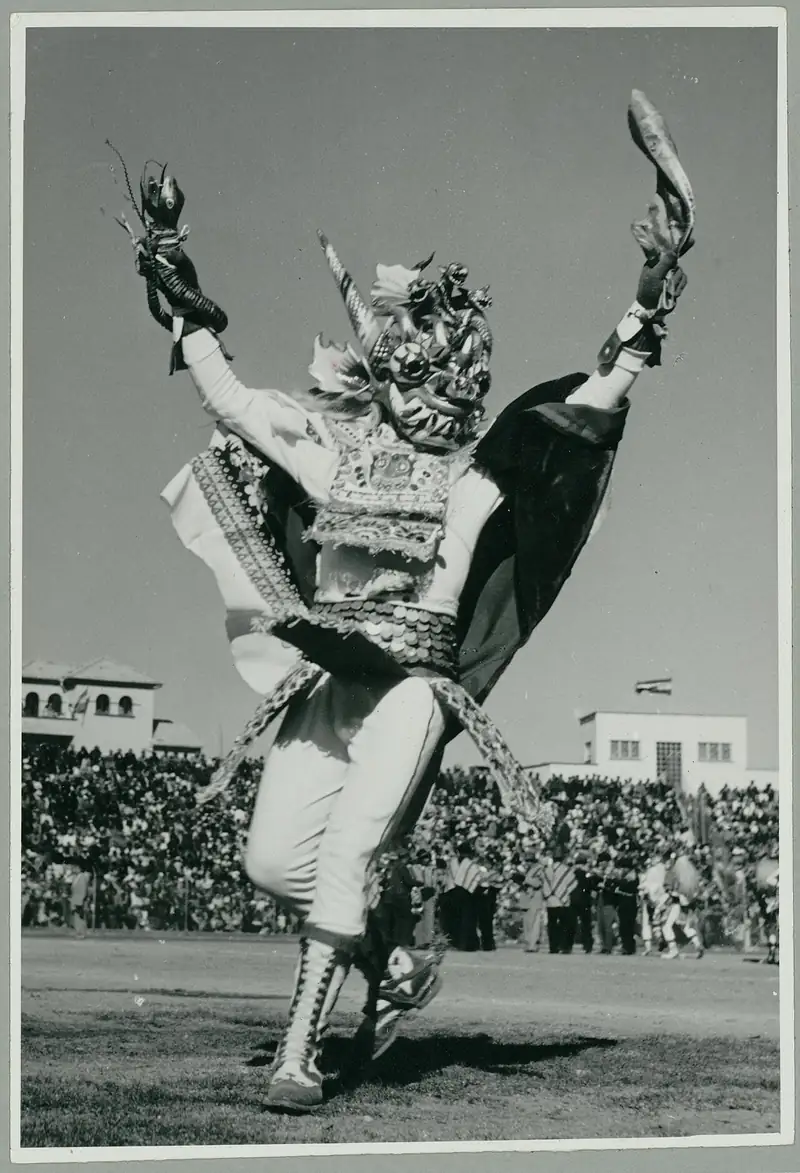 Photographie de 1970 : un danseur de la Diablada portant un masque de diable cornu et un costume brodé